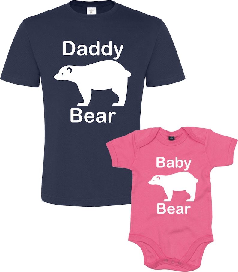 May include: A navy blue t-shirt with the text "Daddy Bear" and a white polar bear graphic. A pink baby onesie with the text "Baby Bear" and a white polar bear graphic.