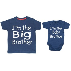 May include: Two navy blue t-shirts with white text. The larger shirt says "I'm the Big Brother". The smaller shirt says "I'm the Baby Brother".