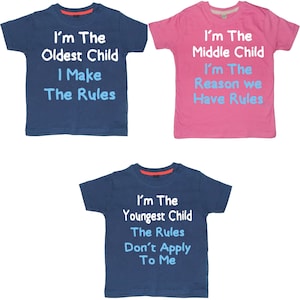 May include: Three blue and pink t-shirts with white text. The shirts say "I'm the Oldest Child I Make the Rules", "I'm the Middle Child I'm the Reason we Have Rules", and "I'm the Youngest Child The Rules Don't Apply To Me".
