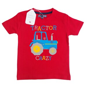 May include: Red short-sleeved t-shirt with a blue tractor graphic and the text "TRACTOR CRAZY" in colorful letters.