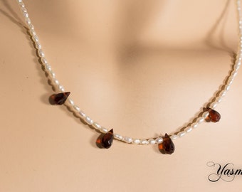 Freshwater cultured pearl with faceted Garnet