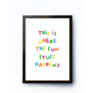 May include: A black framed print with the text "This is where the fun stuff happens" in colorful letters.
