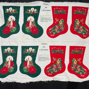 May include: A fabric panel with six Christmas stocking designs. Two green stockings with candles and poinsettias, and four red stockings with birdhouses and greenery. The words "Home for Christmas" are printed on the fabric.