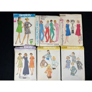 Może przedstawiać: Kolekcja vintage kopert z wykrojami do szycia. Wzory przedstawiają ilustracje sukienek, kombinezonów i bluzek. Marki to m.in. Simplicity i McCall's. Koperty prezentują różne kolory i style z połowy XX wieku.