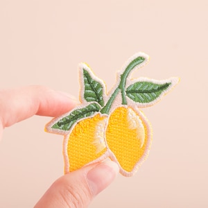 May include: Embroidered iron-on patch of two yellow lemons with green leaves on a branch.