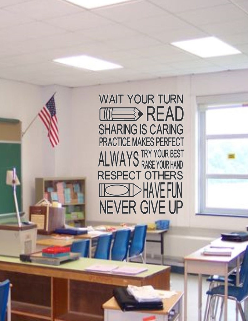 May include: A classroom scene with an American flag and motivational text on the wall. The text includes phrases like "Wait Your Turn," "Read," and "Never Give Up." Desks and chairs are visible, suggesting a learning environment.