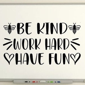 May include: A white dry-erase board with black text that reads "Be Kind Work Hard Have Fun". Two black bee silhouettes are on either side of the text.
