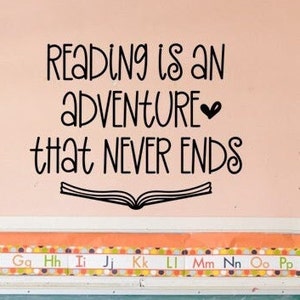 May include: Black and white text on a pink wall that reads "Reading is an adventure that never ends". A black and white illustration of an open book is below the text. A colorful alphabet border is below the text.