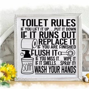 May include: A white sign with black text that reads "Toilet Rules" and includes instructions for using the toilet, such as "If you lift it up...put it down", "If it runs out...replace it", "If you are finished...flush it", "If you miss it...wipe it", "If it smells...spray it!" and "Wash your hands".