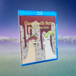 Könnte beinhalten: Eine blaue Blu-ray-Hülle mit dem Titel Llamas with Hats The Complete Series. Das Cover zeigt zwei gezeichnete Lamas vor einem Blumenhintergrund mit roten Tropfen, eines trägt einen braunen Hut und das andere eine grün-gelb gestreifte Mütze.