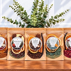 May include: Five brown kraft paper pouches containing dried fruit, spices, and botanicals for stovetop potpourri. Each pouch features a circular label with the text Apple Harvest, Holiday, Cabin Brew, Frosted Citrus, or Mistletoe and natural ingredients.