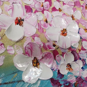 Op de afbeelding: Een close-up van een schilderij met witte en roze bloemen met gele en blauwe accenten. De bloemen zijn geschilderd in een textuurrijke stijl, waardoor het schilderij een driedimensionaal effect krijgt.