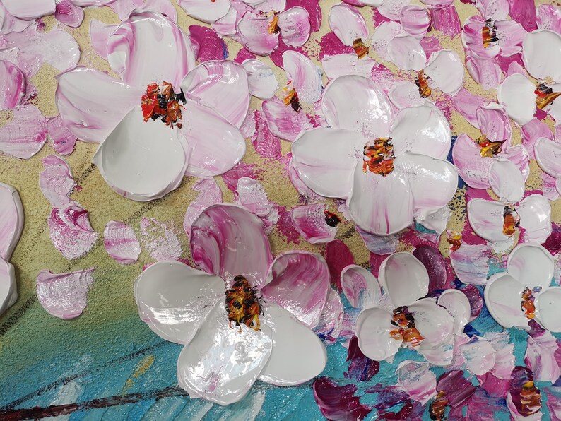 Op de afbeelding: Een close-up van een schilderij met witte en roze bloemen met gele en blauwe accenten. De bloemen zijn geschilderd in een textuurrijke stijl, waardoor het schilderij een driedimensionaal effect krijgt.