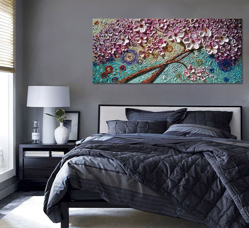 Op de afbeelding: Een groot canvas schilderij van een roze en witte bloeiende boom met een blauwe en groene achtergrond. Het schilderij heeft een textuur, 3D-effect.