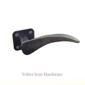 Może przedstawiać: Czarny metalowy klamka do drzwi z zakrzywionym uchwytem i kwadratową płytką. Tribes Iron Hardware jest nadrukowane pod klamką.