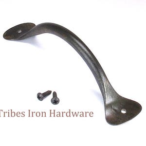 May include: Black metal door pull handle with rounded ends and two screw holes. The handle is curved and has a rustic finish. Two black screws are included.