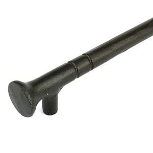 Puede incluir: Pomo de puerta de metal negro con un extremo redondeado ligeramente acampanado y una pequeña proyección cuadrada en el lateral.