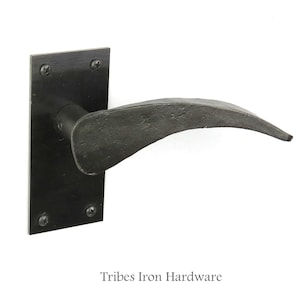 Puede incluir: Pomo de puerta de hierro negro con una palanca curva y una placa posterior rectangular. La manija está hecha por Tribes Iron Hardware.