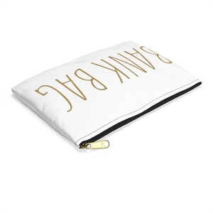 May include: White zippered pouch with the text "BAG THANK" written in gold.