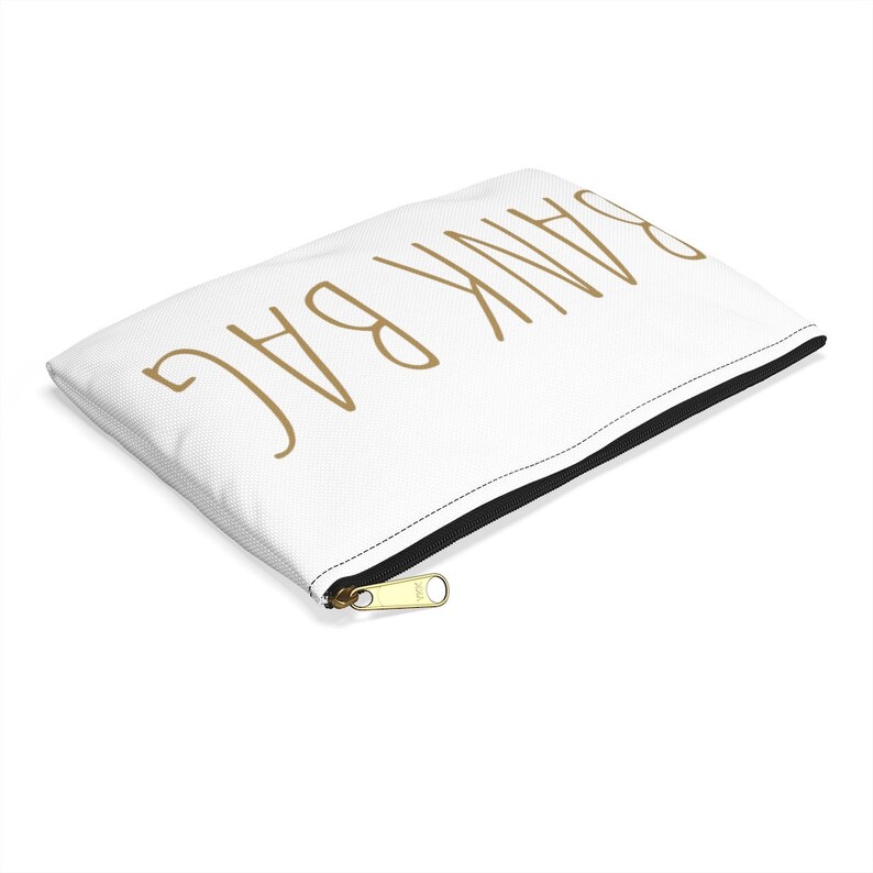 May include: White zippered pouch with the text "BAG THANK" written in gold.