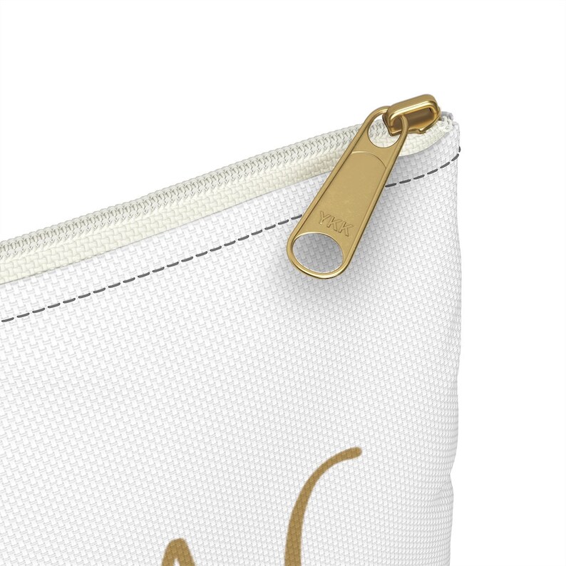 May include: White canvas zippered pouch with a gold zipper pull. The zipper pull has the text "YKK" on it.