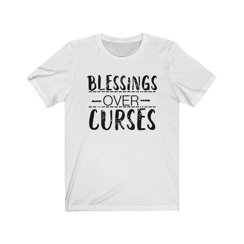 May include: White t-shirt with black text that reads "Blessings Over Curses".
