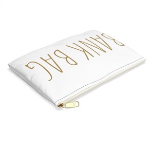 May include: White zippered pouch with the words "Thank You" written in gold script.