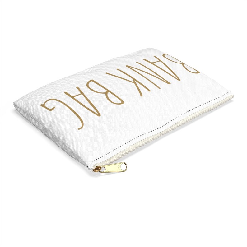 May include: White zippered pouch with the words "Thank You" written in gold script.