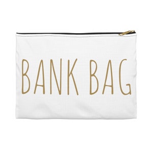 May include: White zippered pouch with the text "BANK BAG" in gold lettering.