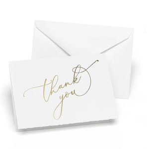 May include: White thank you cards with gold foil lettering. The cards are blank inside and come with white envelopes.