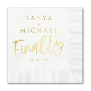 May include: White square paper napkin with gold text. The text reads "Tanya + Michael Finally 09.24.22". The napkin has a textured border on the bottom and right side. Ideal for weddings and special events.