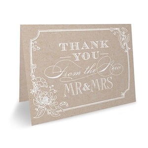 May include: A thank you card with a brown background and white text that reads "Thank You - From the New Mr. & Mrs." with a floral design around the border.