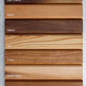 Pode incluir: Uma cole&ccedil;&atilde;o de amostras de madeira mostrando v&aacute;rios tipos e cores de madeira. As amostras incluem Light Walnut, Beech, Walnut, Ash, Cherry, Brown Maple e White Oak. Cada amostra &eacute; rotulada com seu respectivo nome.