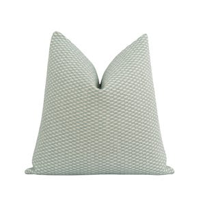 Pu&ograve; includere: Un cuscino decorativo quadrato con un motivo strutturato blu chiaro e bianco. Il cuscino ha una palette di colori morbidi e neutri e un design sottile e intrecciato, adatto per aggiungere un tocco di eleganza a qualsiasi stanza.