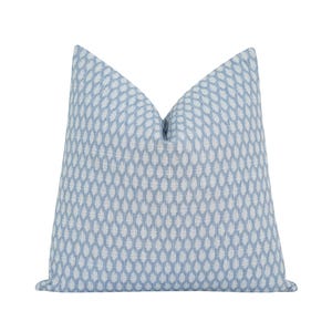 May include: A square decorative pillow with a light blue background and a repeating white teardrop pattern. The pillow has a soft, textured appearance and is designed for home decor.