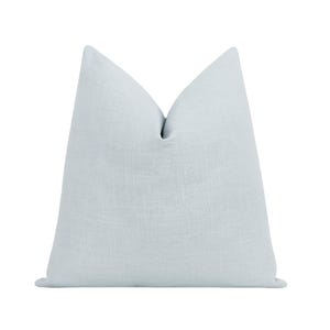 May include: A light blue decorative pillow with a textured linen appearance. The pillow is a solid color and has a simple, elegant design. The pillow is a soft, comfortable addition to any living space.
