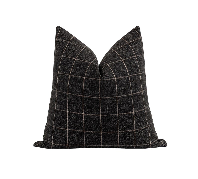 May include: Black and white checkered throw pillow with a subtle pink grid pattern.