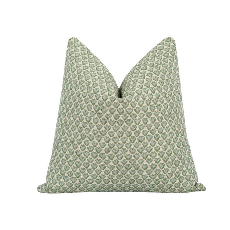 May include: A green and white patterned throw pillow with a heart design.