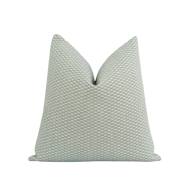Pu&ograve; includere: Un cuscino decorativo quadrato con un motivo strutturato blu chiaro e bianco. Il cuscino ha una palette di colori morbidi e neutri e un design sottile e intrecciato, adatto per aggiungere un tocco di eleganza a qualsiasi stanza.