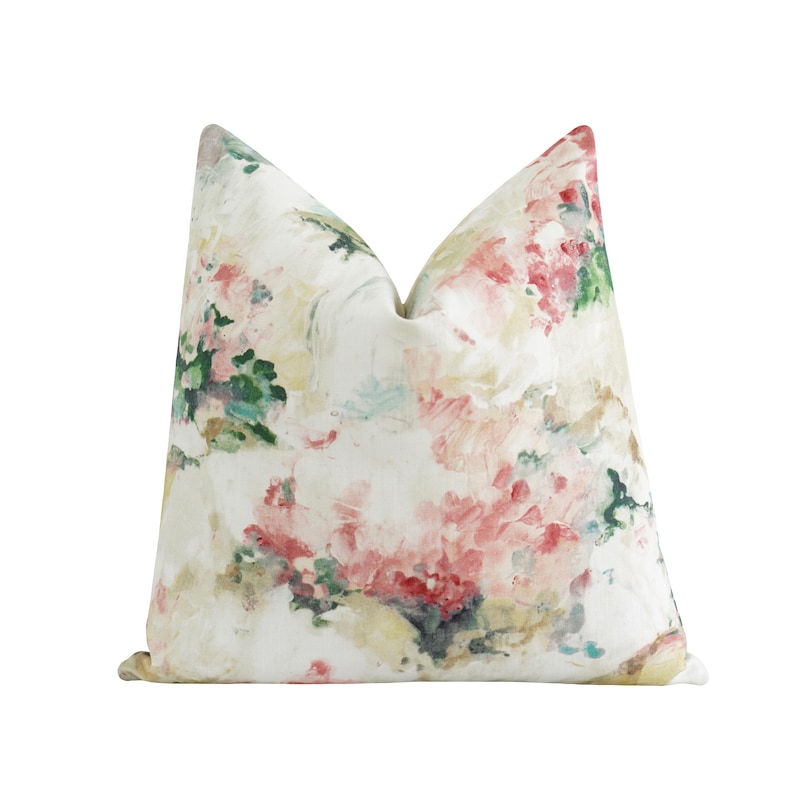 K&ouml;nnte beinhalten: Ein quadratisches Zierkissen mit floralem Muster. Das Kissen hat einen wei&szlig;en Hintergrund mit einem Aquarell-Design in Rosa, Rot, Gr&uuml;n und Gelb. Es eignet sich f&uuml;r die Dekoration im Wohnbereich.