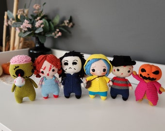 May include: A set of seven crocheted plush toys, including a green monster, a red-haired girl, a blue-faced monster, a yellow-haired girl, a red and black striped character, a pumpkin, and a green monster.