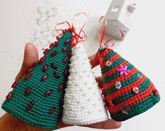 Puede incluir: Tres adornos de árbol de Navidad hechos a crochet. Uno es verde con cuentas rojas, otro es blanco con cuentas blancas y el último es verde y rojo con lentejuelas de colores.