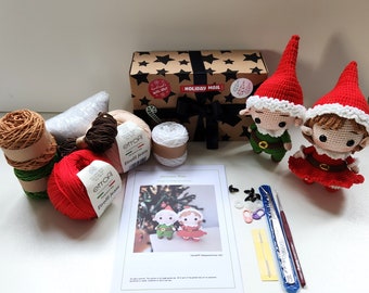 Könnte beinhalten: Ein Weihnachts-Elfen-Häkelset mit Garn, Nadeln, Knöpfen und Anleitungen. Das Set enthält zwei Elfen, einen in Grün und einen in Rot.