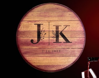 May include: A round wooden sign with the initials "J K" and the date "1-14-2023" engraved on it. The sign is made from reclaimed wine barrel staves and has a rustic appearance.