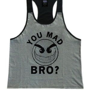May include: A gray tank top with a black racerback. The front of the tank top has a black and white graphic of a smiley face with the text "You Mad Bro?" printed on it.