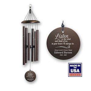May include: A bronze wind chime with a round, engraved metal tag that reads "Listen to the wind and think of me. In your heart I'll always be. Always Loved & Forever Missed Edward Barnes 1944-2021". The tag is attached to the chime with a black cord. The chime is made in the USA.