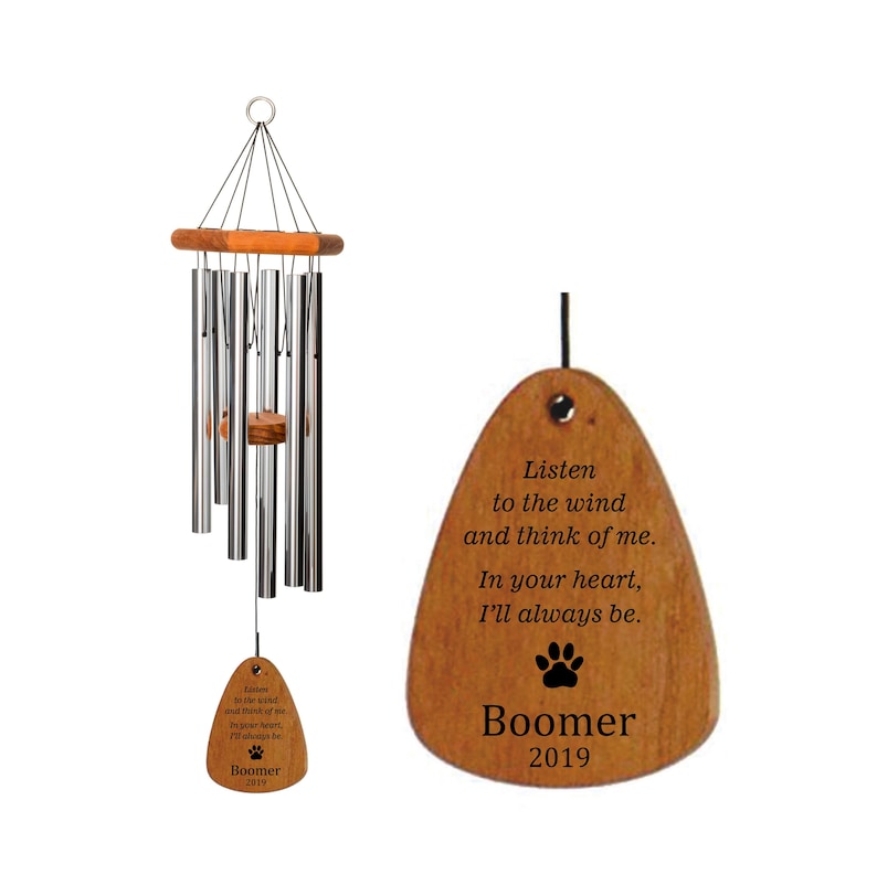 May include: A wooden wind chime with a metal chime tube and a wooden tag that reads "Listen to the wind and think of me. In your heart, I'll always be. Boomer 2019".