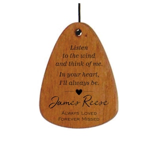 May include: Wooden wind chime with a heart and the text "Listen to the wind and think of me. In your heart, I'll always be. James Reese ALWAYS LOVED FOREVER MISSED"