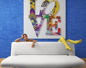 May include: A white sofa with a woman sitting on it. The woman is wearing yellow tights and is looking at the camera. Behind the sofa is a large white canvas with the word "LOVE" written in colorful letters. The letters are made up of various images and patterns.
