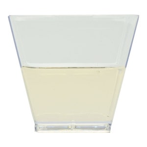 May include: A clear plastic square dish filled with a light yellow liquid.